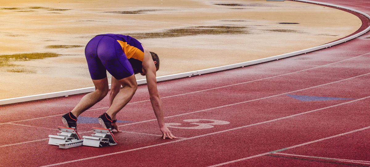 track and field athlete getting set to run on the starting blocks